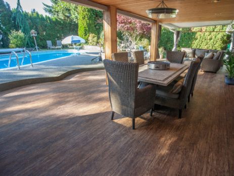 Covered deck next to a backyard pool, newly resurfaced with Tufdek outdoor waterproof vinyl decking
