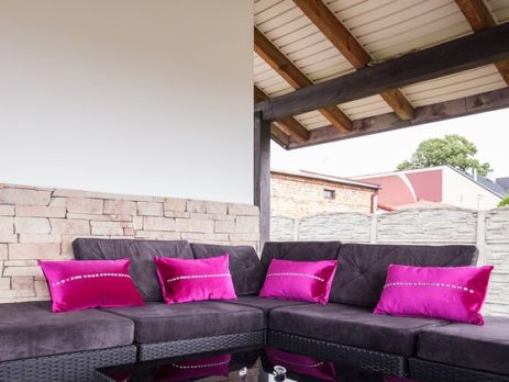 Dark purple deck furniture with neon bright purple pillows