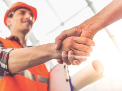 Construction worker in hard hat shaking hands with someone