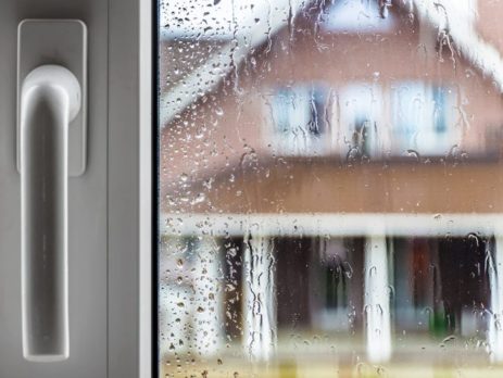 Door handle plus looking through rain soaked window at neighbouring house
