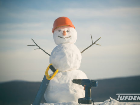 Snowman with construction hat, saw and electric drill