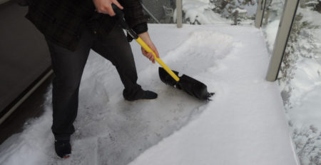 Man shovelling snow off a vinyl deck